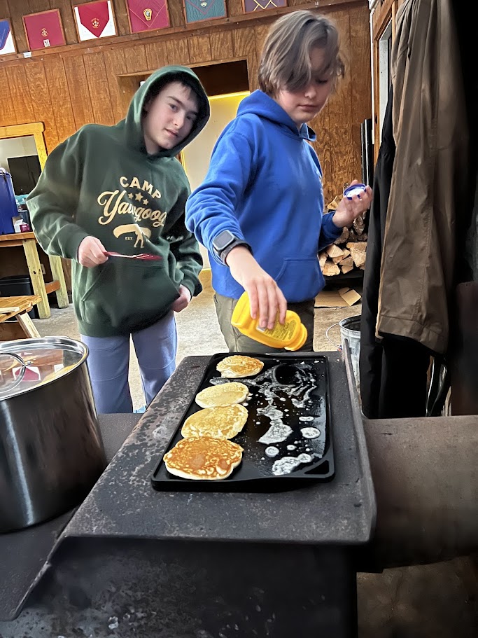 Scouts cooking during the ice fishing trip.